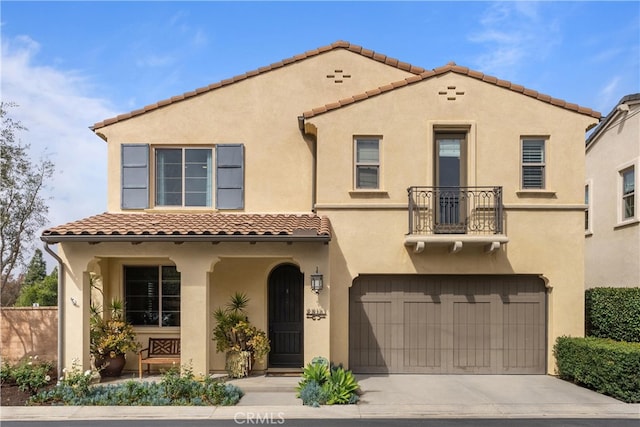 mediterranean / spanish-style home featuring a tiled roof, a balcony, driveway, and stucco siding