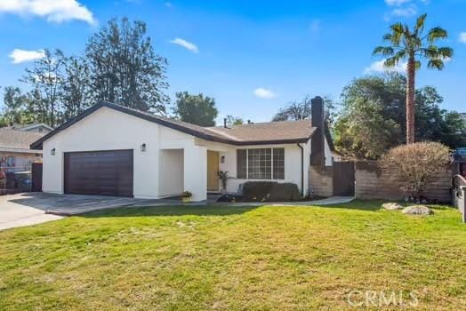 single story home with an attached garage, driveway, a front lawn, and stucco siding