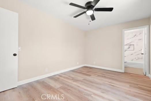 empty room featuring ceiling fan, baseboards, and wood finished floors