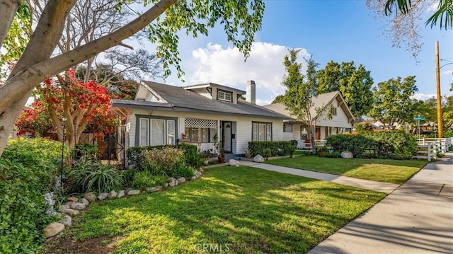 view of front of property featuring a chimney and a front lawn