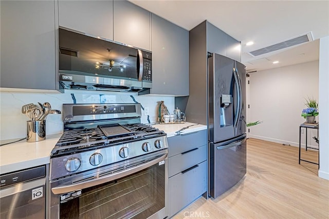 kitchen featuring appliances with stainless steel finishes, gray cabinets, and modern cabinets