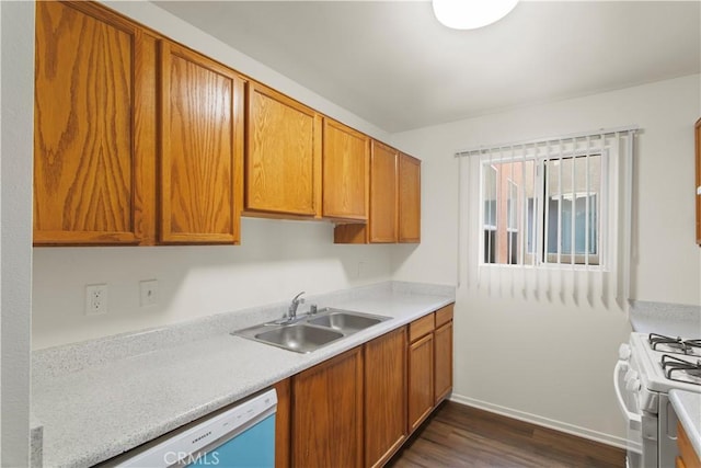 kitchen featuring dishwasher, dark wood-style flooring, white gas range, light countertops, and a sink