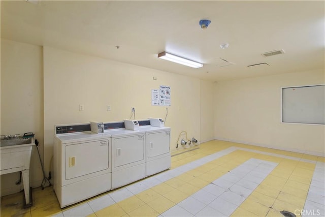 community laundry room featuring visible vents and separate washer and dryer