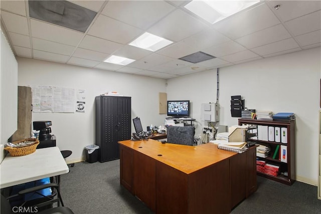 office with a drop ceiling, dark carpet, and baseboards