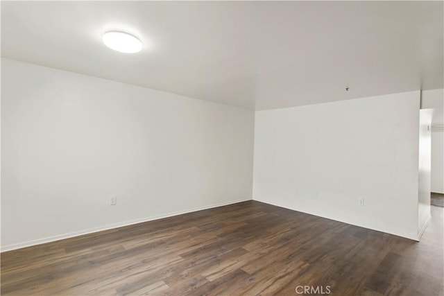 unfurnished room featuring dark wood-style flooring