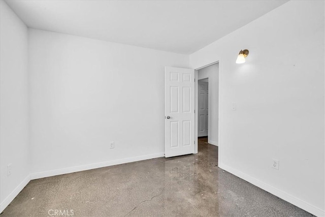 empty room with concrete floors and baseboards