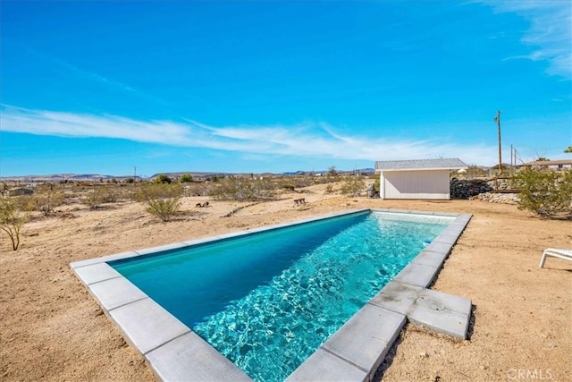 outdoor pool featuring an outbuilding and a shed