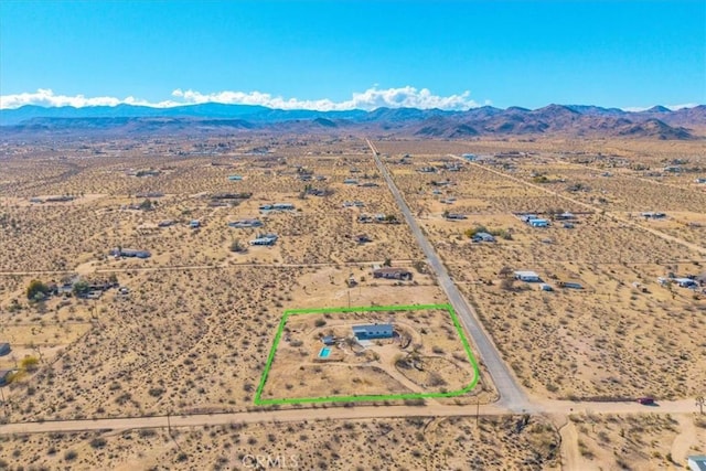 drone / aerial view featuring view of desert, a rural view, and a mountain view