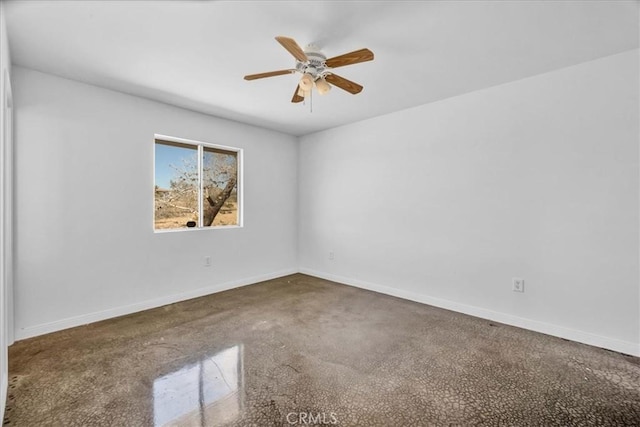 empty room with ceiling fan and baseboards