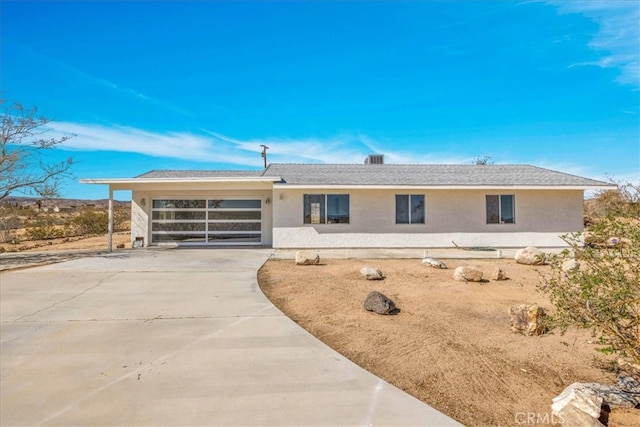 view of front of home featuring an attached garage, concrete driveway, and stucco siding