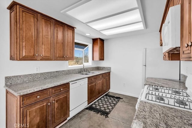 kitchen with white appliances, baseboards, brown cabinetry, concrete floors, and a sink