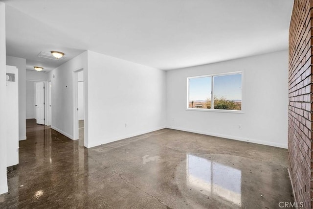 spare room with finished concrete flooring and baseboards