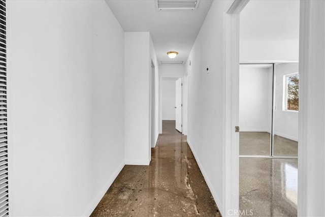 corridor featuring baseboards, visible vents, and attic access