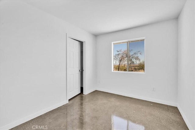 unfurnished bedroom featuring finished concrete floors and baseboards