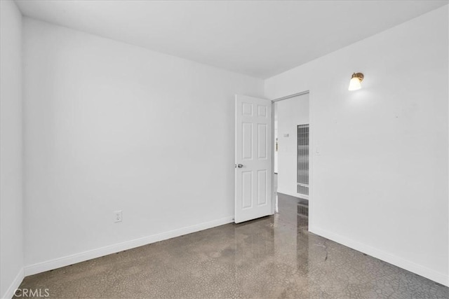 unfurnished room with baseboards