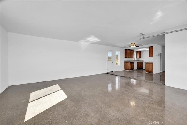 unfurnished living room featuring a barn door and a ceiling fan