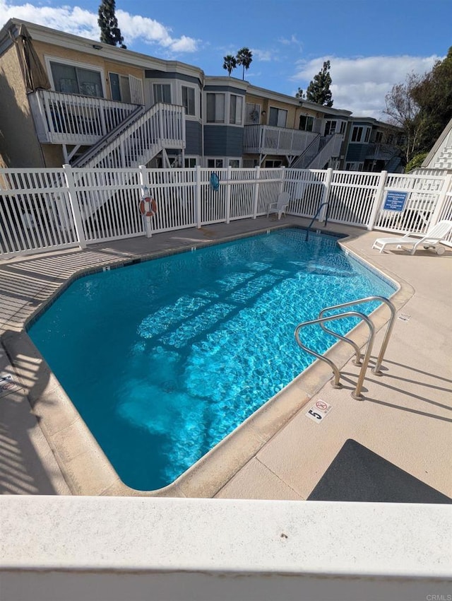 community pool featuring fence and a patio