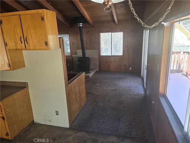 kitchen featuring a healthy amount of sunlight, wood walls, wood ceiling, and beamed ceiling