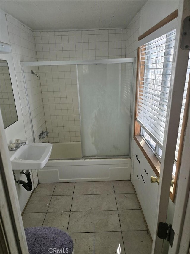 bathroom featuring a sink, shower / bath combination with glass door, plenty of natural light, and tile patterned flooring