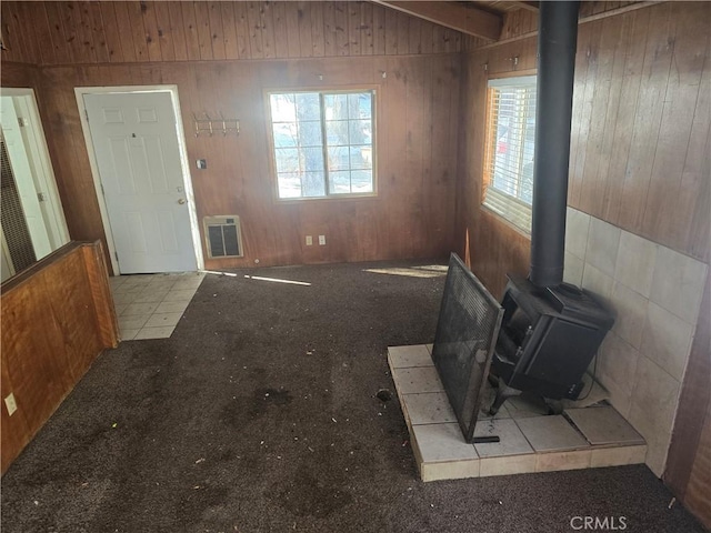 living area featuring a wood stove, heating unit, and lofted ceiling