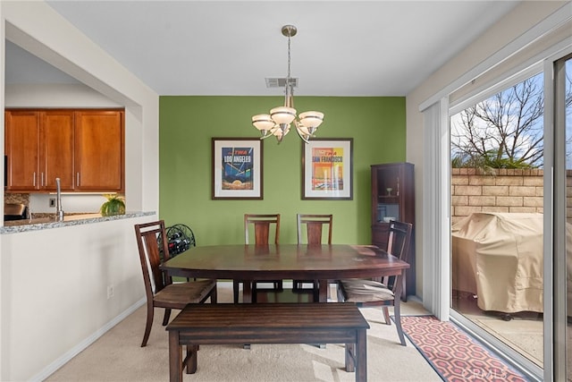 dining space featuring visible vents, light carpet, baseboards, and an inviting chandelier