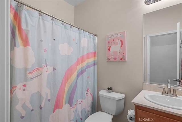 bathroom featuring toilet, a shower with shower curtain, and vanity