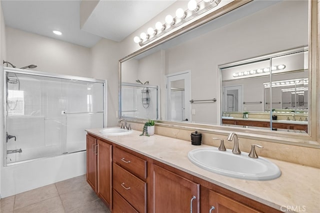 bathroom with double vanity, enclosed tub / shower combo, a sink, and tile patterned floors