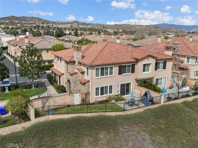 exterior space with a mountain view, a fenced backyard, and a residential view