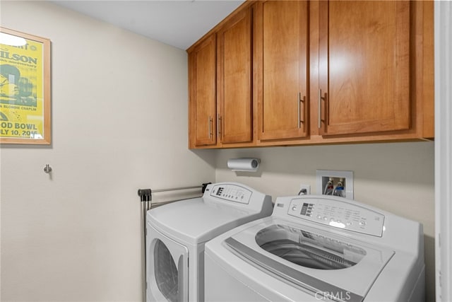 clothes washing area featuring cabinet space and independent washer and dryer