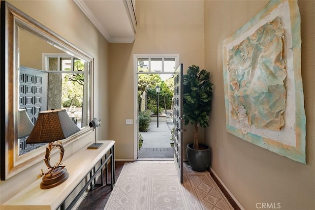 doorway featuring ornamental molding and baseboards