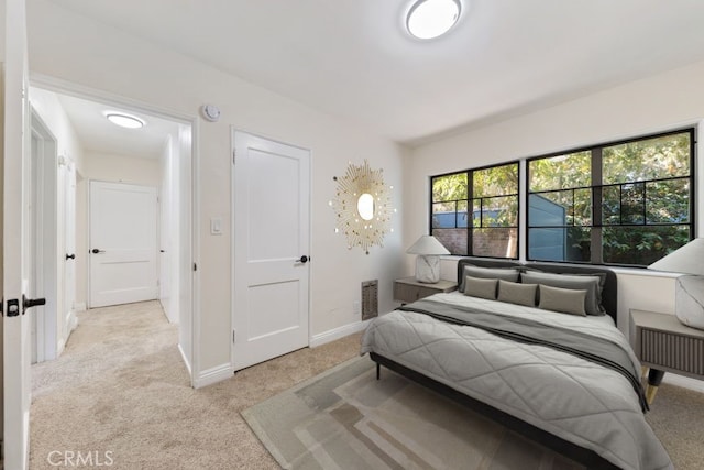 bedroom with light colored carpet and baseboards