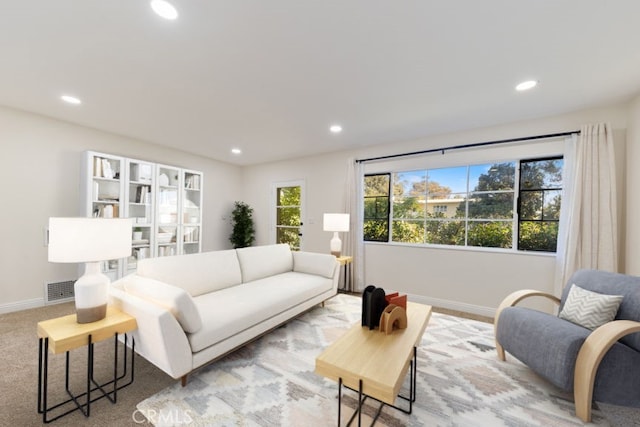 living room with baseboards, visible vents, and recessed lighting