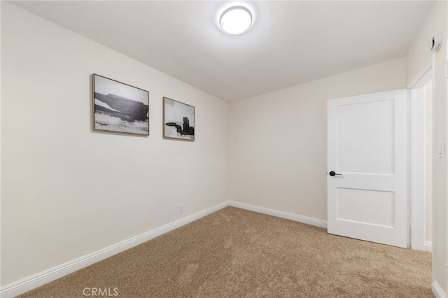 carpeted spare room with baseboards