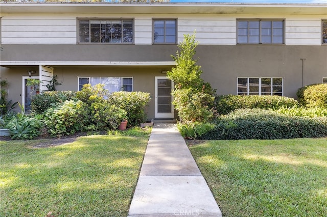 view of front facade featuring a front yard and stucco siding