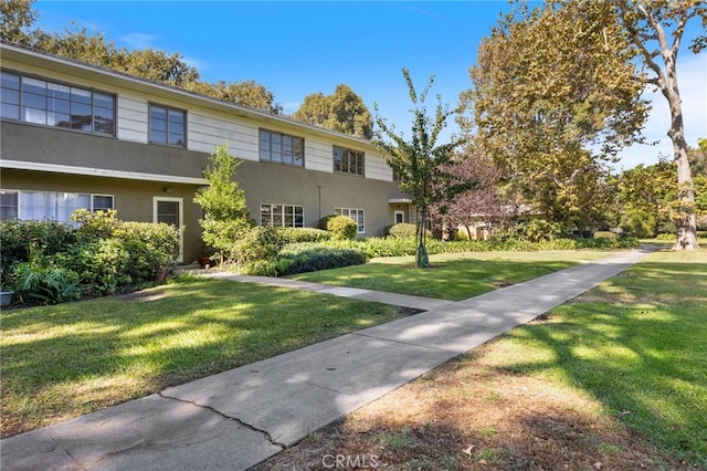 view of front of house featuring a front lawn and stucco siding