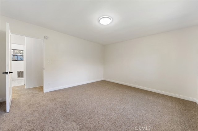 unfurnished room with baseboards, visible vents, and light colored carpet