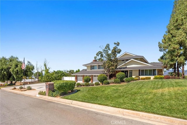 view of front of property with concrete driveway and a front yard