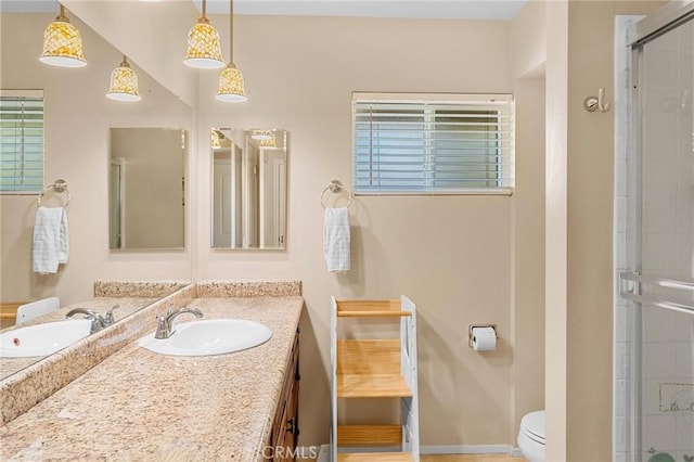 bathroom featuring a stall shower, baseboards, vanity, and toilet