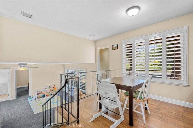 dining area featuring visible vents, baseboards, and wood finished floors