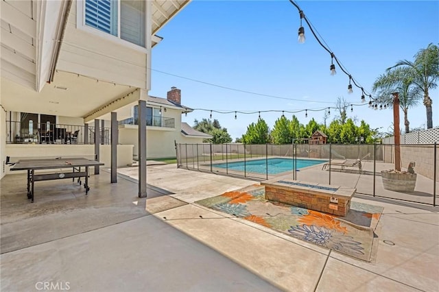 view of pool with a fire pit, a patio, fence, and a fenced in pool