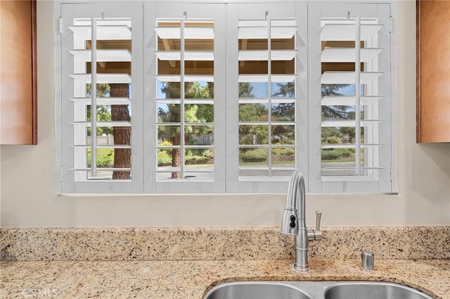 room details featuring light stone countertops and a sink