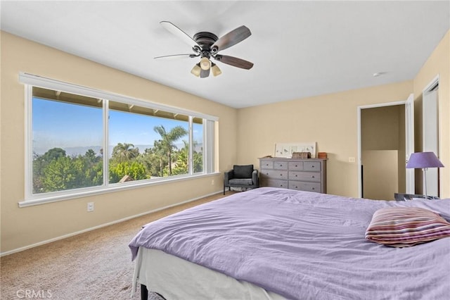 carpeted bedroom featuring ceiling fan and baseboards