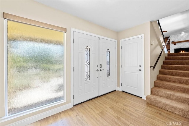 foyer entrance with stairway and light wood-style floors