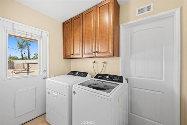 washroom with cabinet space, visible vents, and washer and clothes dryer