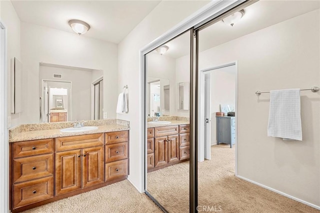 bathroom with carpet floors, vanity, and baseboards