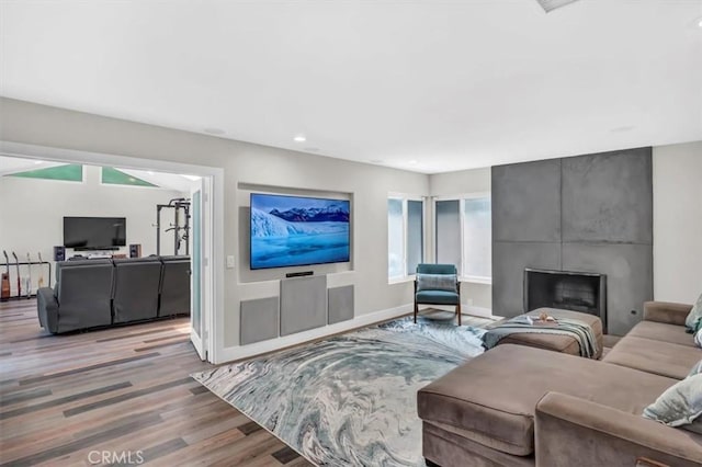 living room featuring recessed lighting, a fireplace, wood finished floors, and baseboards