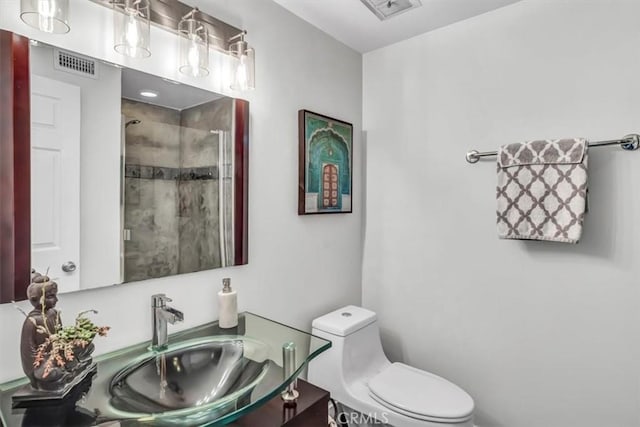 full bathroom with toilet, a stall shower, vanity, and visible vents