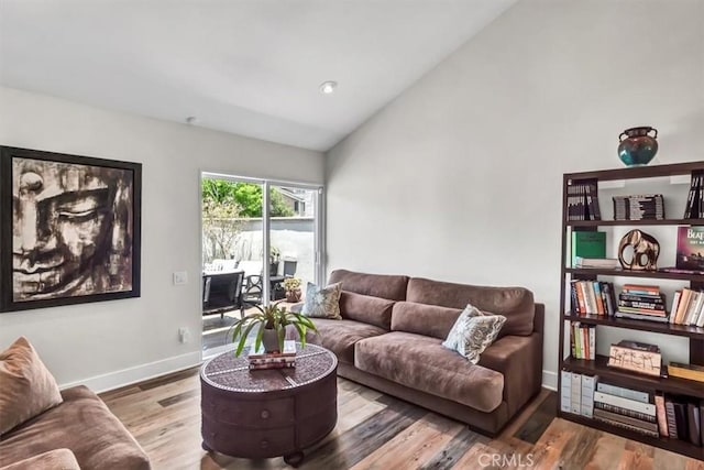 living area featuring high vaulted ceiling, baseboards, and wood finished floors