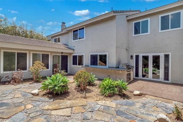 back of property featuring french doors, a patio area, and stucco siding