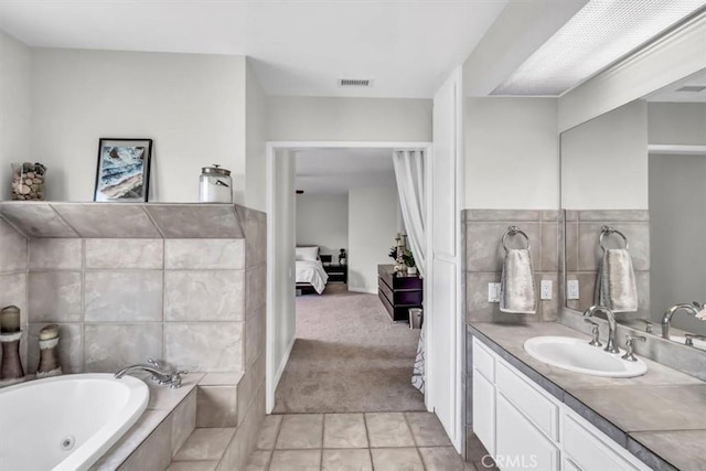 ensuite bathroom featuring connected bathroom, vanity, visible vents, tile patterned floors, and a whirlpool tub